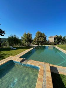 a large swimming pool in a yard with trees at Siviri Traditional Stone House in Siviri