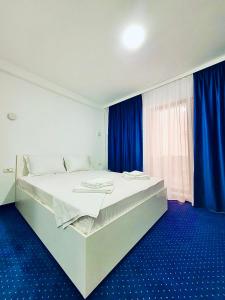 sypialnia z dużym łóżkiem i niebieską podłogą w obiekcie Laguna Grey w mieście Mangalia