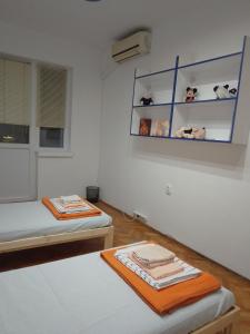 a room with two beds and a shelf with stuffed animals at Стеди - стая за гости in Varna City