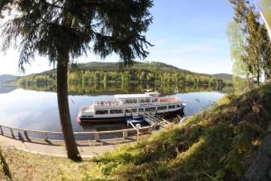 a boat is docked at a dock on a lake at Penzion Pristav in Lipno nad Vltavou