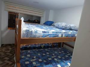 a bunk bed with a blue and white comforter on it at Residencia Chamorro-Dorado in Quito