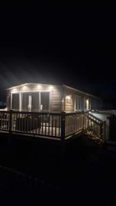 una piccola casa con le luci accese di notte di Ellis Retreats at Tattershall Lakes a Lincoln