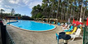 una gran piscina con gente sentada a su alrededor en Cottage 5 personnes Bias Mimizan, en Bias