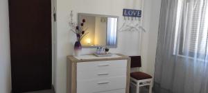 a bathroom with a dresser with a mirror at Vivenda Familia Pedro in Vila do Bispo