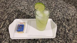 a drink with a lime on a plate with a snack at Motel Jaguar Contagem in Contagem