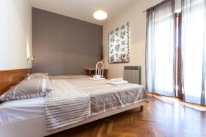 een slaapkamer met een groot bed en een groot raam bij Apartments & Room Diana in Pakoštane