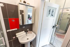a small bathroom with a sink and a mirror at Vintage Senacka 9/7 Apartment in Krakow