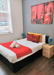 1 dormitorio con 1 cama grande con manta roja en J Quarter - sleeps 5 long term & families comfortably, 4 beds, 2 bathrooms, en Birmingham