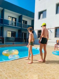 dwóch młodych chłopców stojących obok basenu w obiekcie Laguna Grey w mieście Mangalia