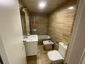 a bathroom with a toilet and a sink and a tub at APARTAMENTO MODERNO Y ACOGEDOR EN EL CENTRO de ALMERÍA in Almería