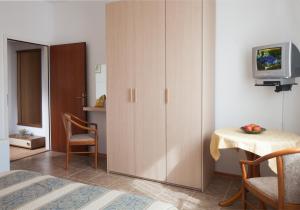 um quarto com um armário, uma mesa e uma televisão em B&B Moderno em Fažana