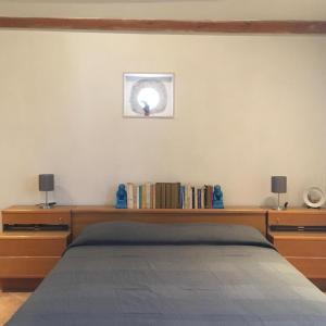 1 dormitorio con cama y estante con libros en La Casa del Carrubo con Piscina condivisa in campagna vicino al mare - Canestanco 18, en Santa Croce Camerina