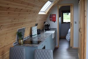a kitchen in a tiny house with wooden walls at Oakwood Luxury Glamping 