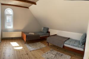 a attic room with two beds and a window at Apartment Vanilla in Struer