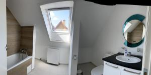 ein weißes Bad mit einem Waschbecken und einem Fenster in der Unterkunft Apartment Vanilla in Struer