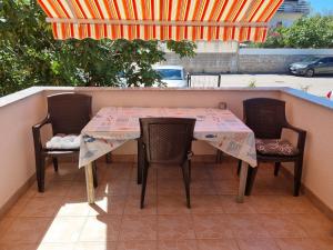 a table and chairs on a patio with an umbrella at Studio apartment LENI in Banjole