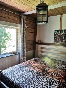 um quarto com uma cama com estampa de leopardo e uma janela em Sagadi Traditional House With The Sauna And Free Parking em Sagadi