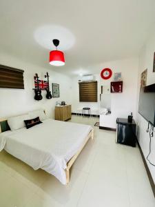 a bedroom with a large bed and a red light at London Unit Tagaytay Wifi/Netflix/Parking in Tagaytay