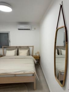um quarto com uma cama e um espelho em BOHO and BE em Qiryat Shemona