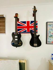 two guitars hanging on a wall with a british flag at London Unit Tagaytay Wifi/Netflix/Parking in Tagaytay