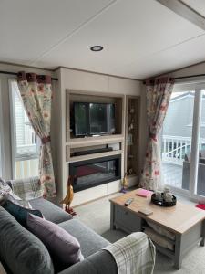 a living room with a couch and a tv at Ellis Retreats at Tattershall Lakes in Lincoln
