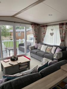 a living room with couches and a table at Ellis Retreats at Tattershall Lakes in Lincoln