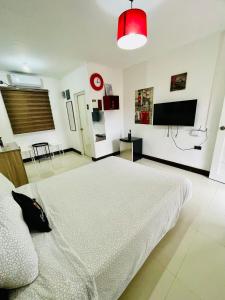 a bedroom with a white bed and a red light at London Unit Tagaytay Wifi/Netflix/Parking in Tagaytay