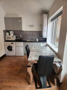 a kitchen with a table and chairs in a room at Cosy Studio Flat in Bexleyheath