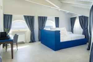a bedroom with a blue bed and a desk at Palazzo San Rocco Residenza Gentilizia in Sperlonga