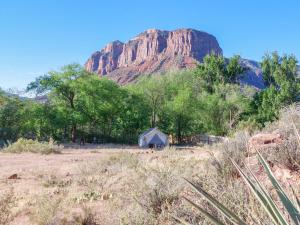 a barn in a field with a mountain in the background at Gateway Glamping in Gateway