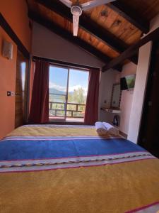 1 dormitorio con 1 cama grande y ventana grande en Hospedaje Anturios Valle de Bravo en Valle de Bravo