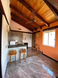 una cocina con paredes de color naranja y techos de madera. en Hospedaje Anturios Valle de Bravo en Valle de Bravo