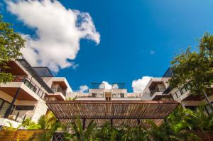 a building with a blue sky in the background at 2 bedroom apartment at Aldea Zama by Casago in Tulum