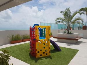 Una estructura de juegos en un césped con el océano de fondo. en Atlântico Norte, en Tambaú