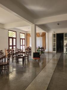 a dining room with tables and chairs and windows at Apartamento em São Lourenço-mg in São Lourenço