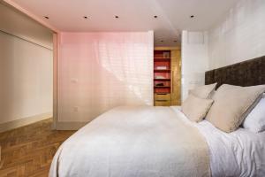 a bedroom with a large bed with white sheets and pillows at The Notting Hill Apartments By Hok Living - Nh1 in London