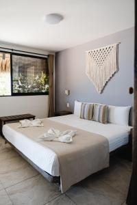 Un dormitorio con una gran cama blanca y una ventana en Casa Bagus, en San Agustinillo