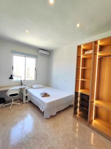 een slaapkamer met een bed, een bureau en een computer bij Luminoso Apartamento enfrente del AVE in Puertollano