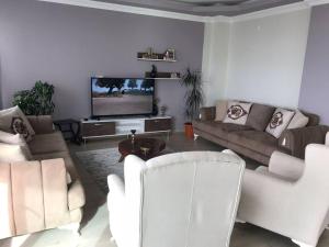un soggiorno con mobili bianchi e TV a schermo piatto di SEA WİEW AND MOUNT WİEW 6 BEDROOMS,4 BATHROMS a Trabzon