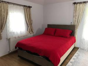 una camera con un letto rosso e due finestre di SEA WİEW AND MOUNT WİEW 6 BEDROOMS,4 BATHROMS a Trabzon