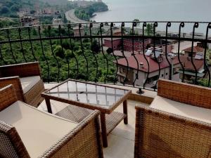 a balcony with tables and chairs and a view of the water at SEA WİEW AND MOUNT WİEW 6 BEDROOMS,4 BATHROMS in Trabzon