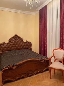 a bedroom with a bed and a chair and a chandelier at Melson in Batumi +8 photos