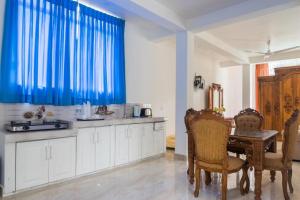 a kitchen with a table and a blue curtain at Emerald Villas Weligama in Weligama