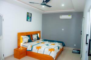 1 dormitorio con 1 cama y ventilador de techo en Résidences 509 en Lomé