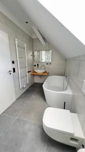 a bathroom with a white tub and a toilet at New Nomads Ferienwohnung am See in Zossen