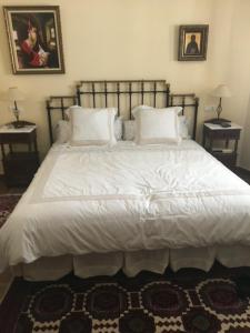 a bedroom with a large bed with white sheets and pillows at Casa Rural "EL CONCEJO" in Aldehuela de la Bóveda