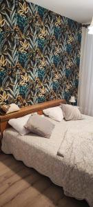 a bed in a bedroom with a floral wallpaper at Vila Bartulović in Kučiće