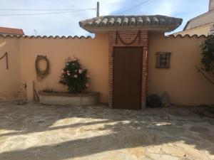 uma casa com uma porta e um plantador à sua frente em Casa Rural "EL CONCEJO" em Aldehuela de la Bóveda