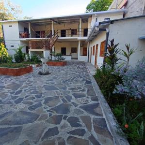uma casa com um pátio de pedra em frente em Hostal las 3 J em Suchitoto