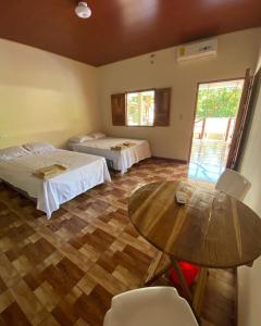a room with two beds and a table in it at Hostal las 3 J in Suchitoto